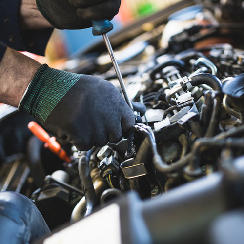 Mechanic tuning up a car engine.