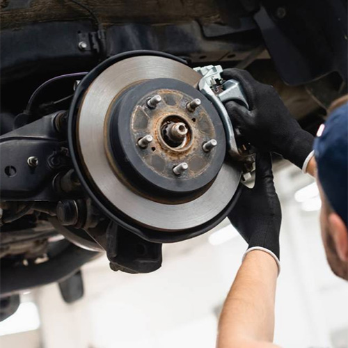 Gloved hands fixing car brakes during brake service in Safety Harbor