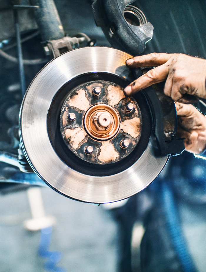 Hands smoothing car brakes during brake service in Safety Harbor
