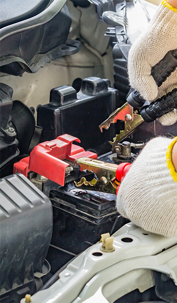 White-gloved mechanic hands working on car battery replacement in Safety Harbor, FL
